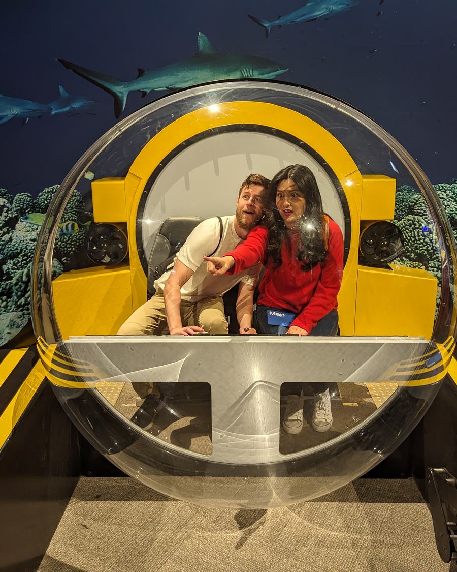 Megan and Tyler sitting inside a bubble submarine at an aquarium