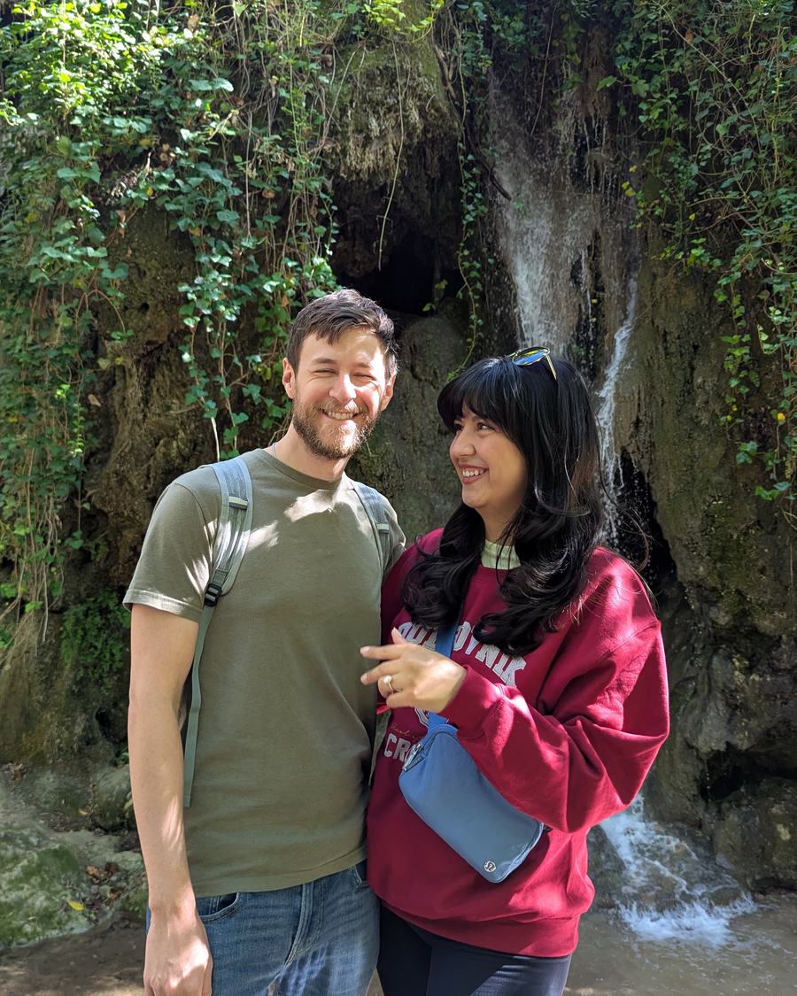 Megan and Tyler in front of a mossy waterfall