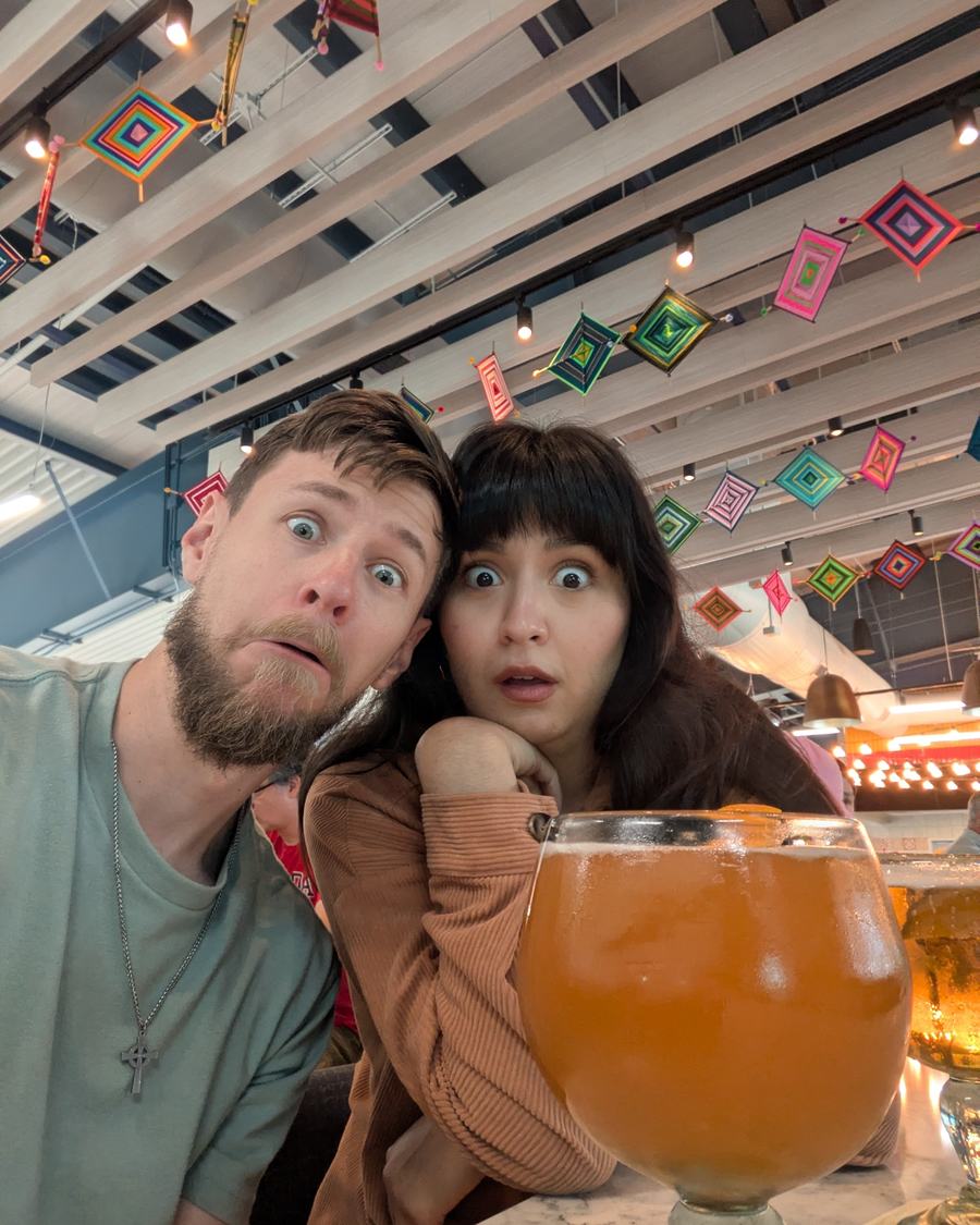 Megan and Tyler wide-eyed beside a giant glass of beer